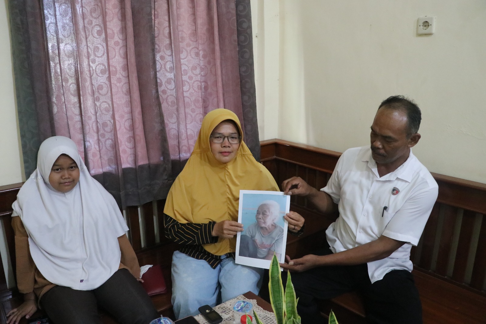 BAHAGIA : Eni Siyamsih, 48, warga Karangrejo, Kecamata Petanahan didampingi Kanit Reskrim Polsek Petanahan menunjukkan foto ibunya yang telah lama berpisah.