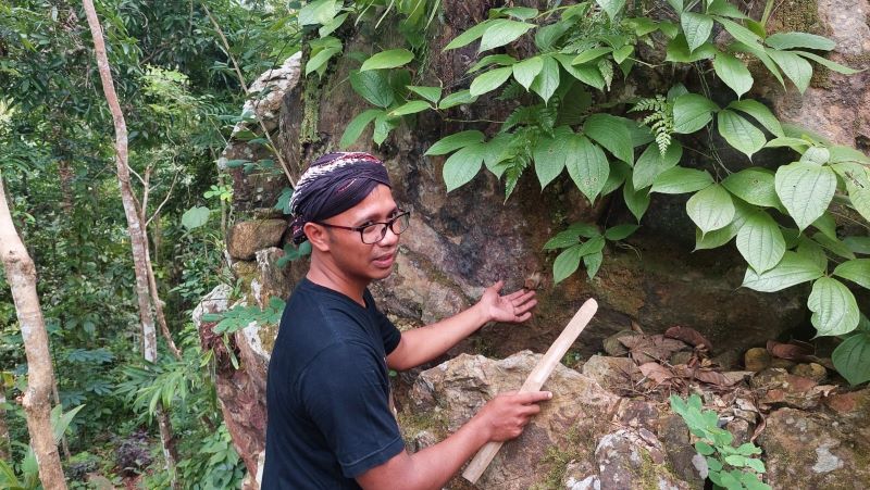 1. Heri menunjukkan batu besar yang bersejarah, didalam batu tersebut terdapat sarang lebah Klanceng yang ada sejak ia belum lahir.