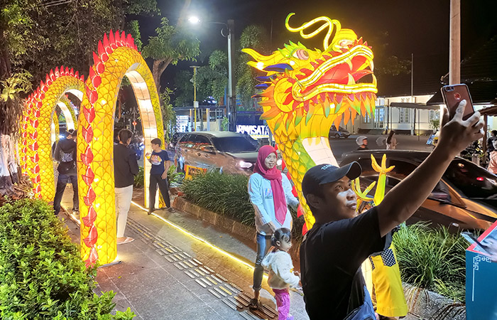 SIMBOL: Warga berfoto di dekat dekorasi berbentuk naga yang dipajang dalam rangka memeriahkan perayaan Tahun Baru Imlek 2024 di kawasan Kotabaru, Kota Jogja kemarin (9/2).