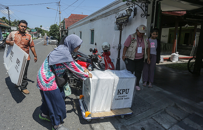 PENDISTRIBUSIAN LOGISTIK: Petugas KPPS membawa logistik pemilu menuju TPS di kawasan Kelurahan Panembahah, Kraton, Jogja, Selasa (13/2)