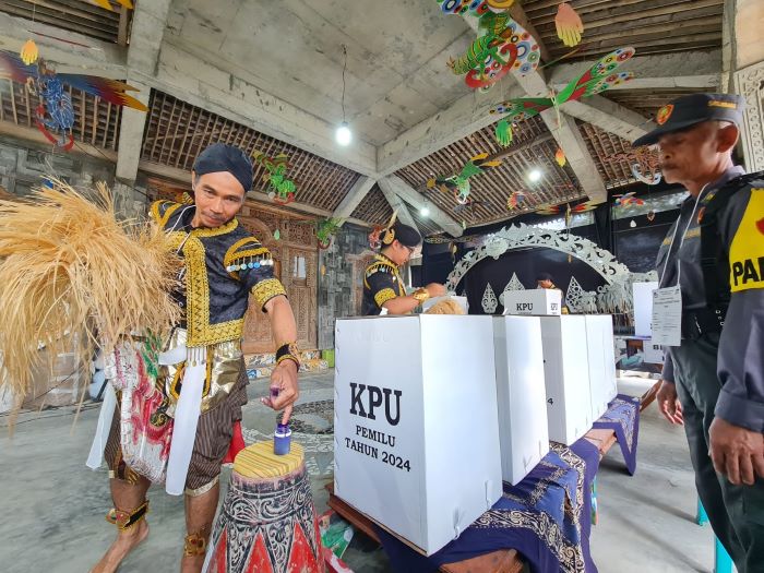 ATRAKTIF: Para petugas kelompok penyelenggara pemungutan suara (KPPS) menampilkan tarian sebelum pencoblosan dimulai, Rabu (14/2/2024).