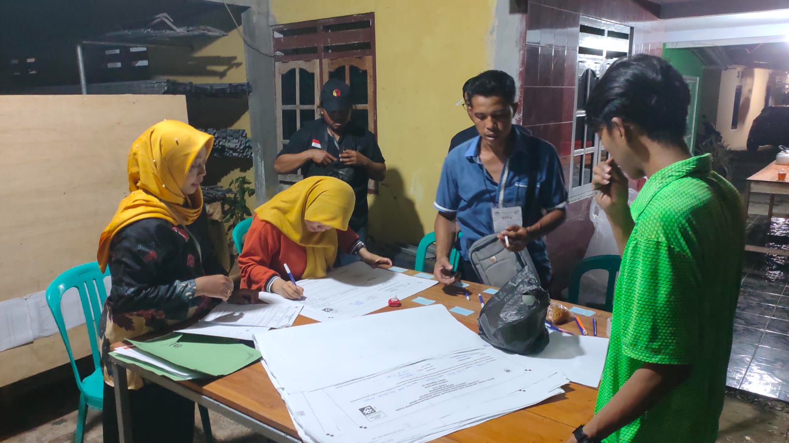 Petugas KPPS di TPS 03 di Desa Dadirejo, Kecamatan Bagelen, Kabupaten Purworejo saat menata perlengkapan di TPS baru. TPS terpaksa direlokasi karena pemilik rumah meninggal dunia, Rabu (14/2)