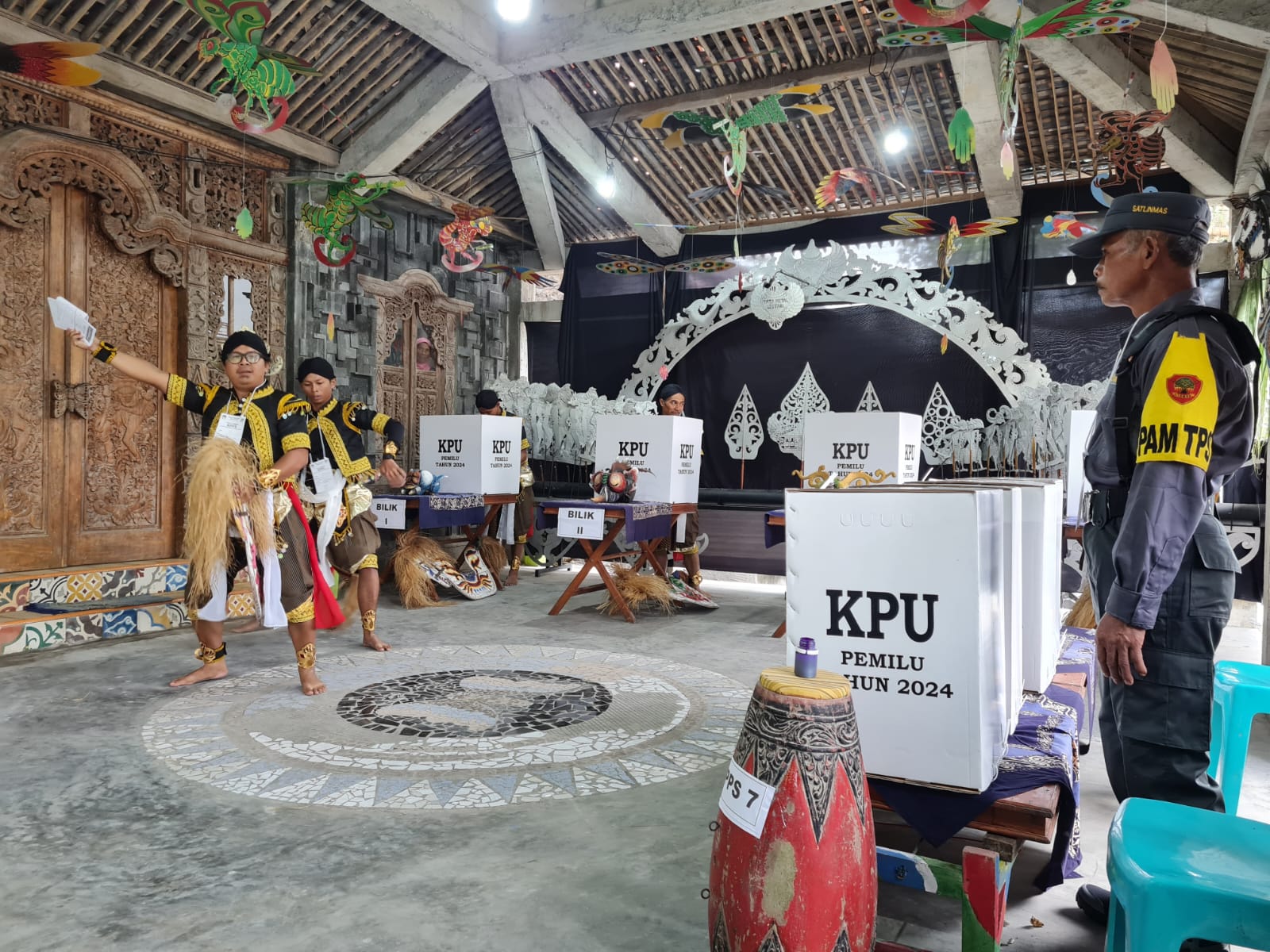 ATRAKTIF: Para petugas kelompok penyelenggara pemungutan suara (KPPS) menampilkan tarian sebelum pencoblosan dimulai, Rabu (14/2/2024) lalu.