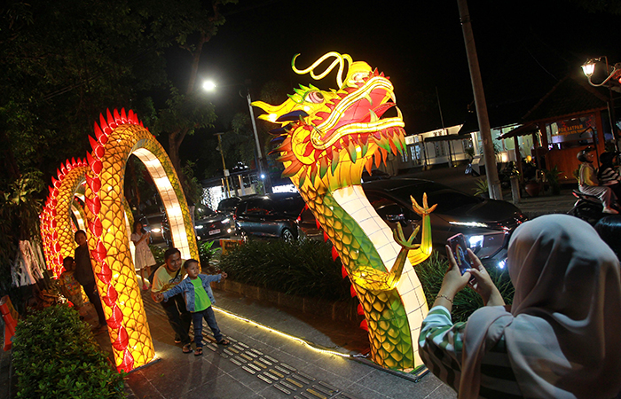 Warga berfoto di dekat dekorasi berbentuk naga yang dipajang dalam rangka memeriahkan perayaan Tahun Baru Imlek 2024, di kawasan Kotabaru, Kota Jogja.