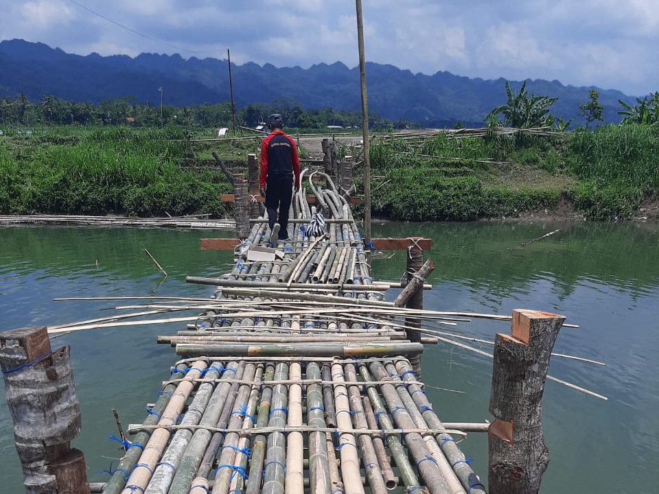 PERLU PERHATIAN : Warga Desa Weton Kulon bersama unsur pemerintah, TNI dan Polri berjibaku memperbaiki jembatan darurat yang rusak pasca diterjang banjir.