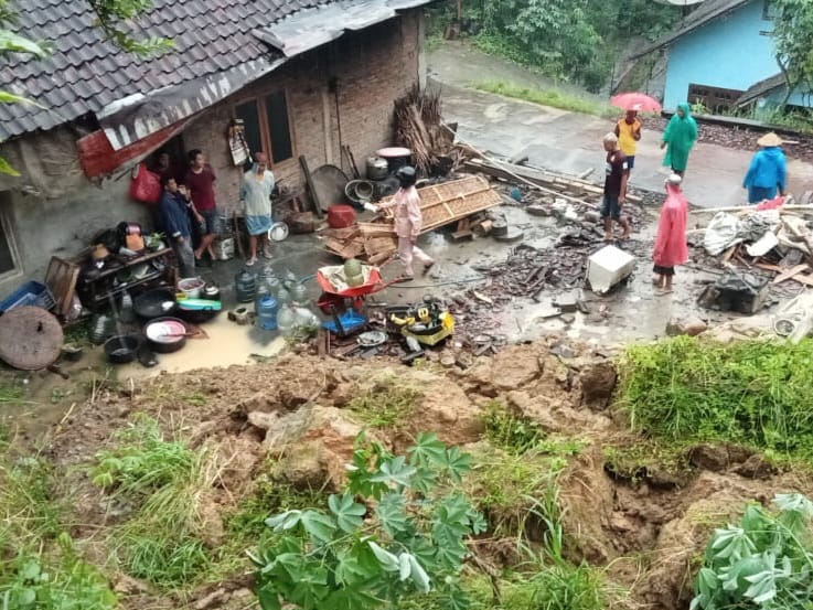 LONGSOR: Warga setempat tengah melakukan kerja bakti terhadap rumah yang longsor pada Minggu (25/2/2024).