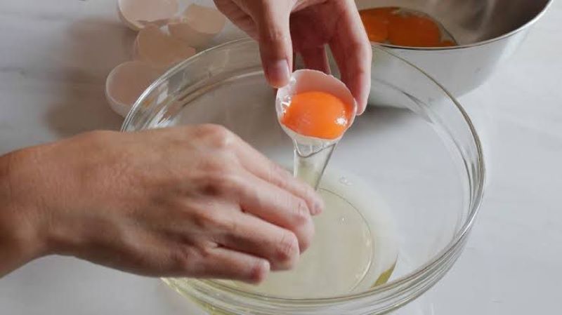 Ilustrasi memisahkan kuning telur dan putih telur. Begini manfaat putih telur bagi kesehatan tubuh.