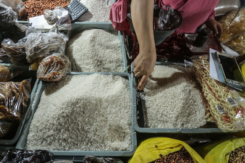 TERSEDIA: Pedagang menunjukkan beras di salah satu pasar tradisional.