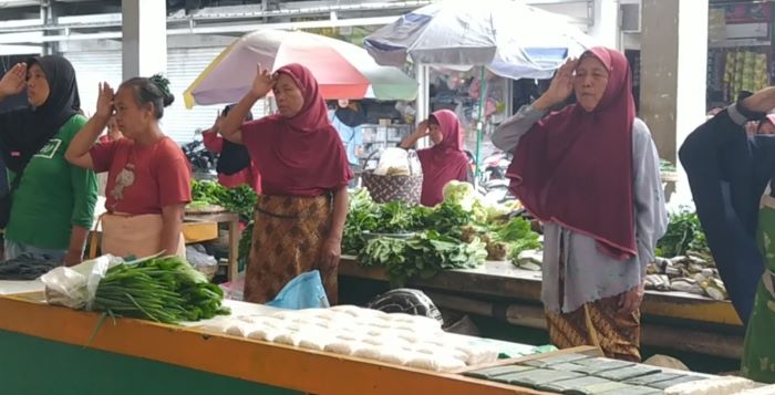 KHIDMAT: Para pedagang di Pasar Rejowinangun Kota Magelang mengentikan aktivitasnya dan mengambil sikap hormat saat lagu Indonesia Raya berkumandang.