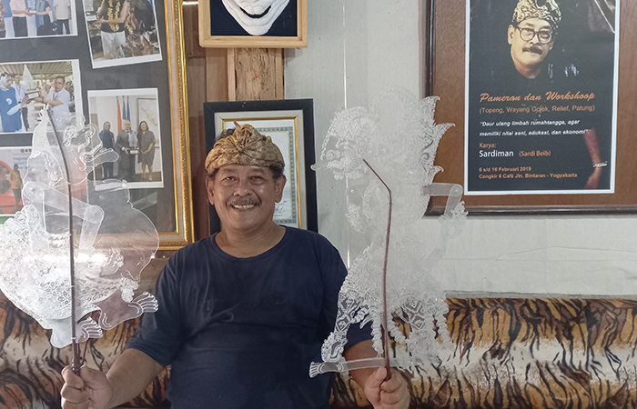 MANFAATKAN LIMBAH: Sardiman alias Sardie Beib saat mengerjakan pembuatan wayang plastik. Ia juga membuat topeng kertas.Khairul Ma