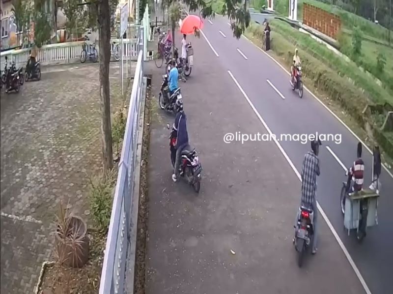 BERAKSI: Seorang pria yang mengenakan baju kotak-kotak tengah mengamati situasi sebelum menggasak ponsel milik ibu berjaket biru gelap.