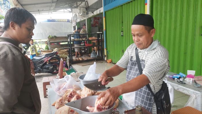 Warijo pedagang ayam sedang melayani pembeli di Pasar Teteg Kulon.