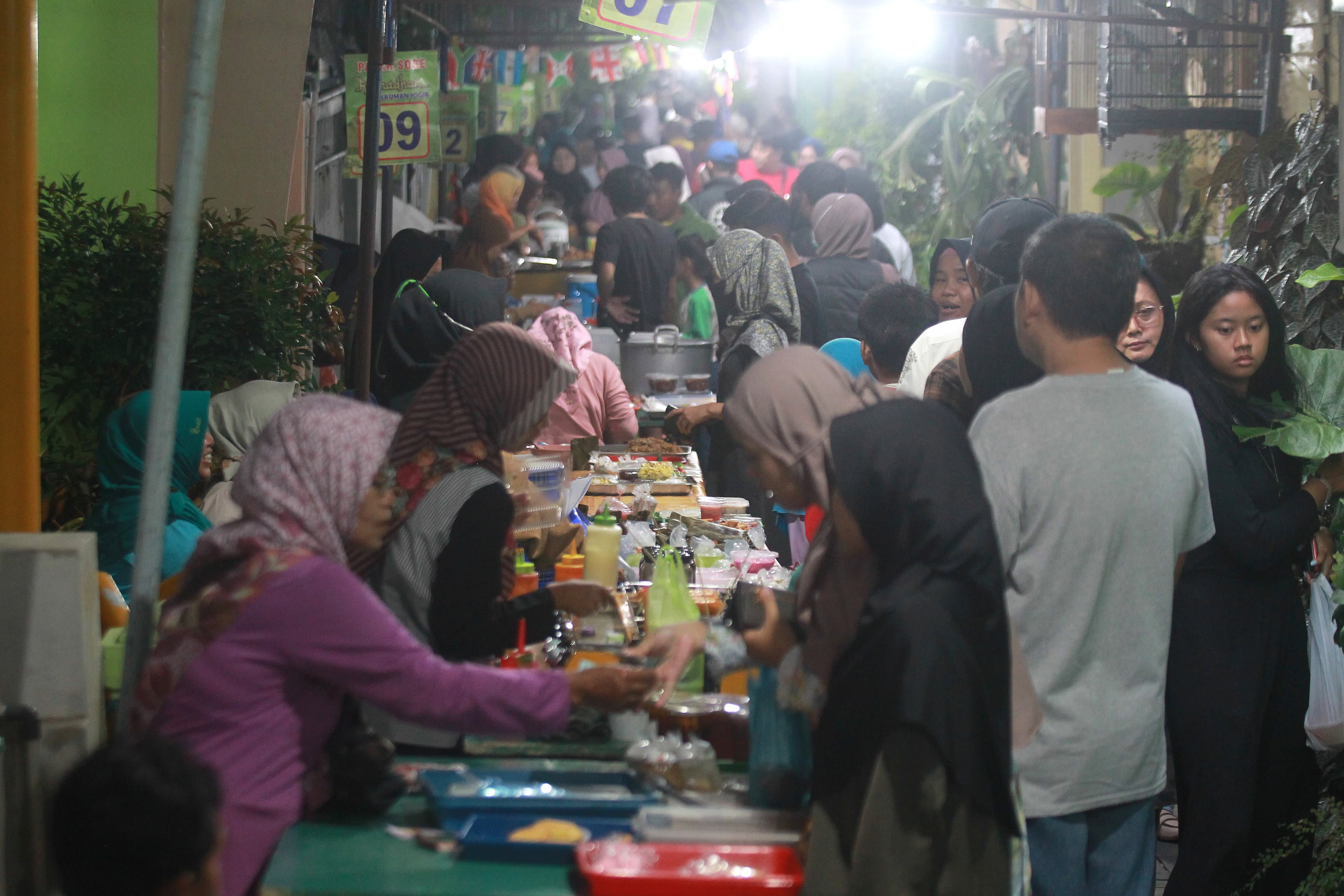 Pedagang melayani para pembeli takjil di Pasar Sore Ramadhan di Kampung Kauman, Kota Jogja, Selasa (12/3/2024). Pasar musiman selama Ramadhan tersebut hingga kini menjadi pusat berburu beragam jajanan