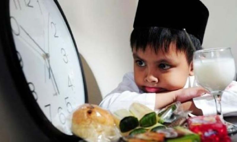 Seorang anak menunggu waktu berbuka puasa.