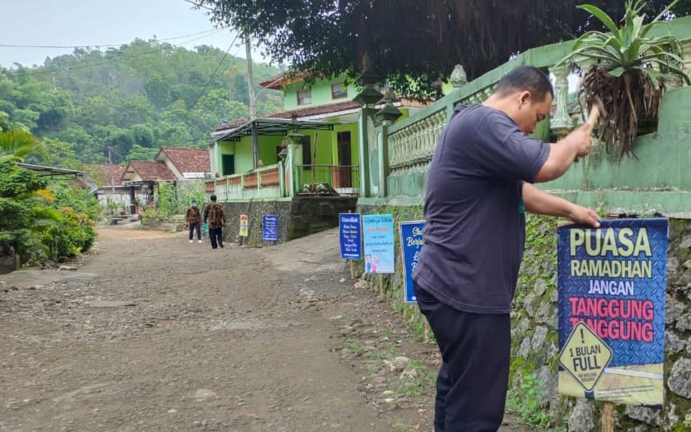 INI LHO - Pak guru memasang rontek berisik kata-kata motivasi tema Ramadan di wilayah Padukuhan Klumpit, Kalurahan Tepus, Kapanewon Tepus