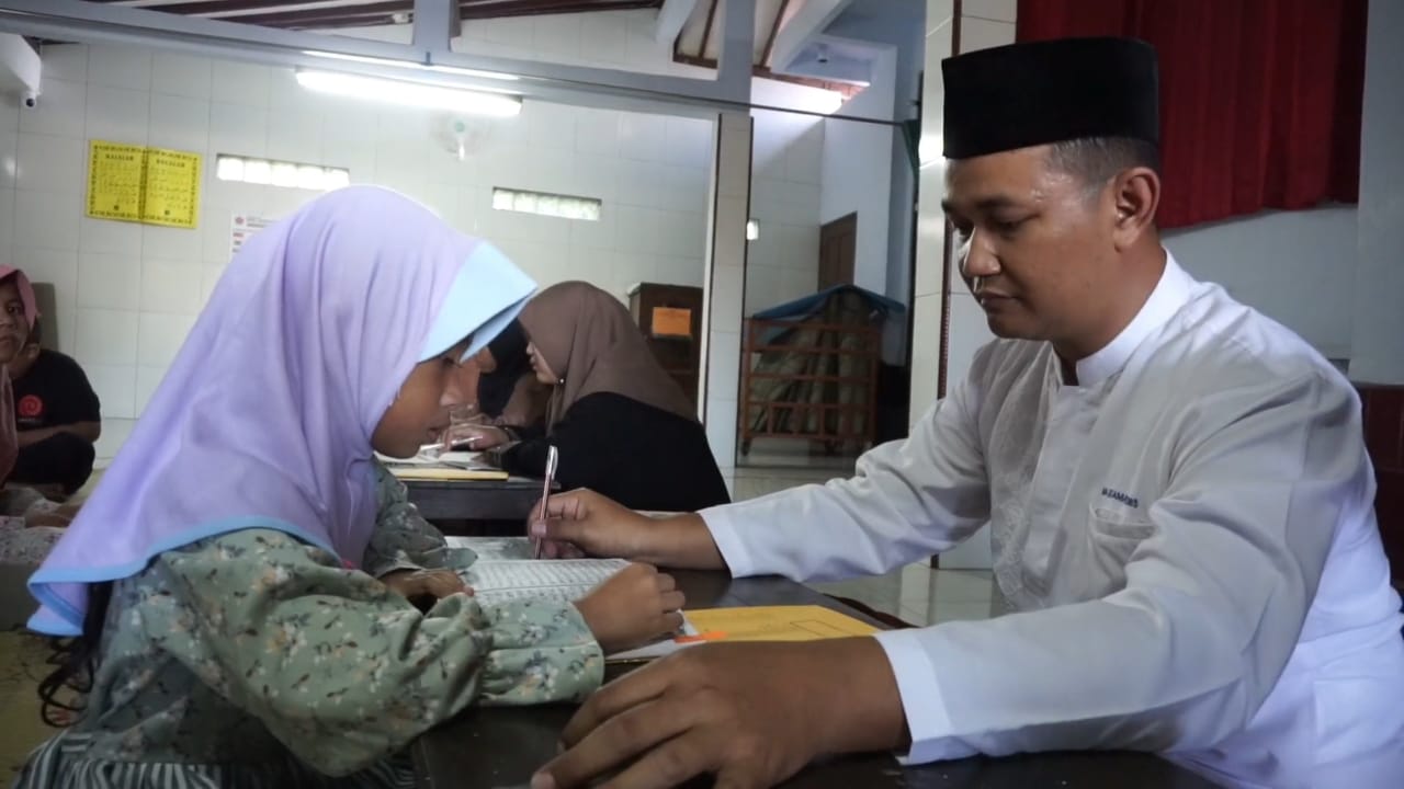 IBADAH: Aipda Andriyanto Widodo sedang mengajari anak-anak untuk membaca Al-Quran.