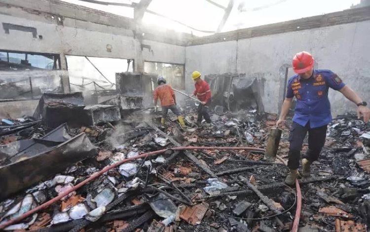 HANGUS: Anggota Satpol PP Kota Mojokerto dan tim relawan membantu proses pemadaman ruangan di RS Gatoel Kota Mojokerto yang terbakar. (foto: Radar Mojokerto/Sofan Kurniawan)