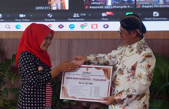 SIMBOLIS: Pada upacara HUT ke-40 Kota Mungkid, Pj Bupati Magelang Sepyo Achanto menyerahkan penghargaan kepada kades Banyusari, Tegalrejo sebagai desa tercepat yang sudah melunasi PBB.