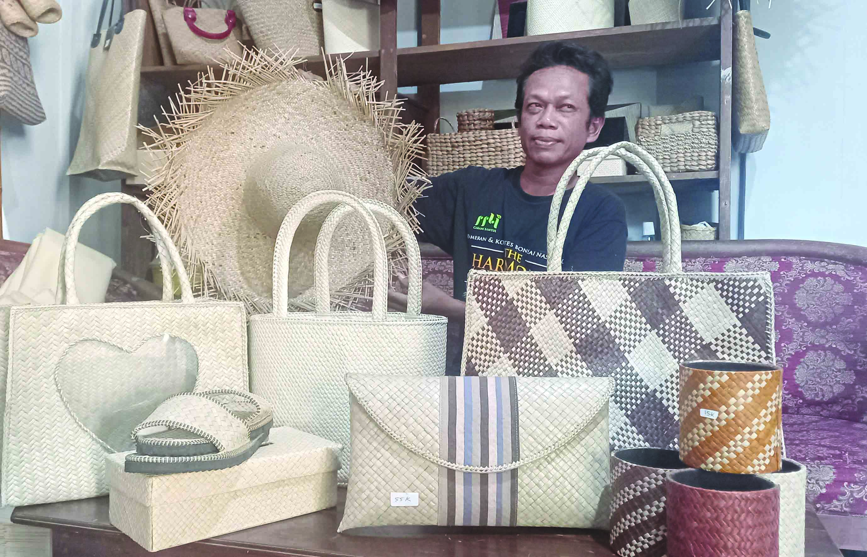 SUDAH EKSPOR: Sutaryono Hasan Basri sedang membuat kerajinan dari anyaman daun pandang. Awaknya tikar, kemudian inovasi ke tas, dompet, topi dan produk lainnya. (Khairul Ma