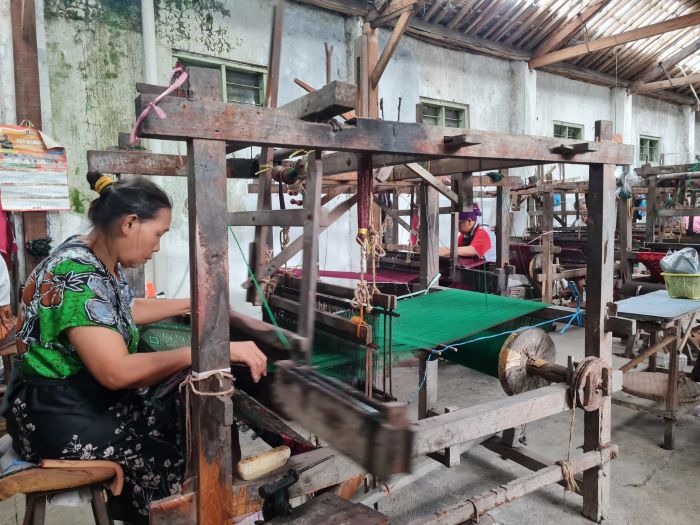 TEKUN: Proses pembuatan sarung tenun cap botol terbang masih menggunakan alat tradisional. Tak heran jika prosesnya lama.