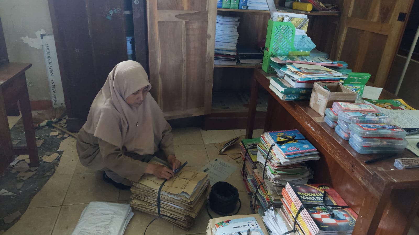 SIBUK: Guru SDN Bugel melakukan pengelompokan buku sebelum dipindahkan. (Anom Bagaskoro/Radar Jogja)