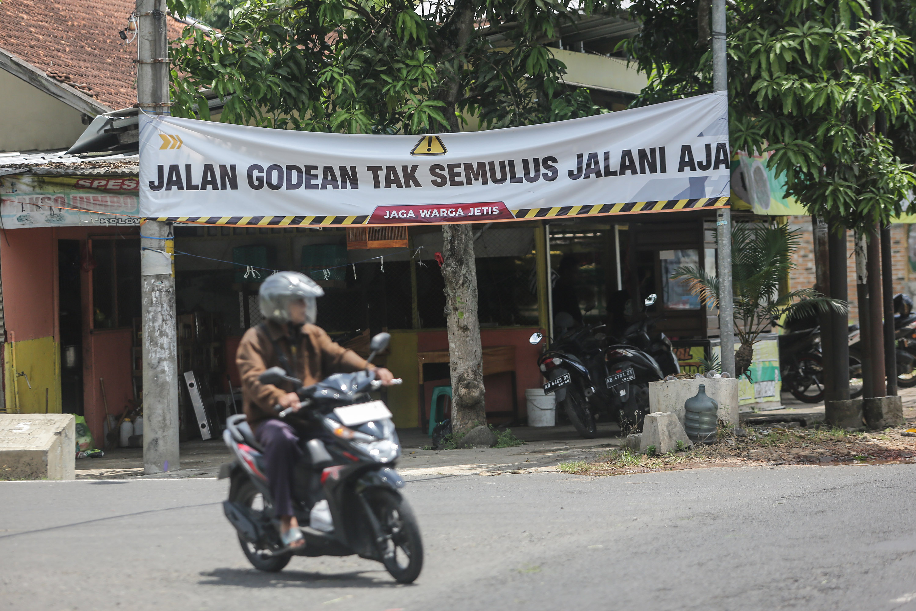 KRITIK: Spanduk kritikan jalan rusak terpasang di jalan Godean-Ngapak, Sendangmulyo, Minggir, Sleman, Sabtu (30/3).