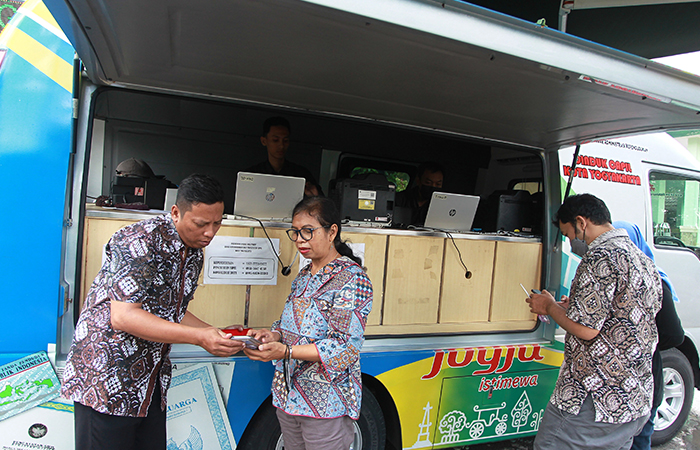MAKIN MUDAH: Warga mengurus proses aktivasi KTP elektronik ke Identitas Kependudukan Digital (IKD) saat berlangsung pelayanan mobil keliling adminduk Dinas Dukcapil Kota Jogja.