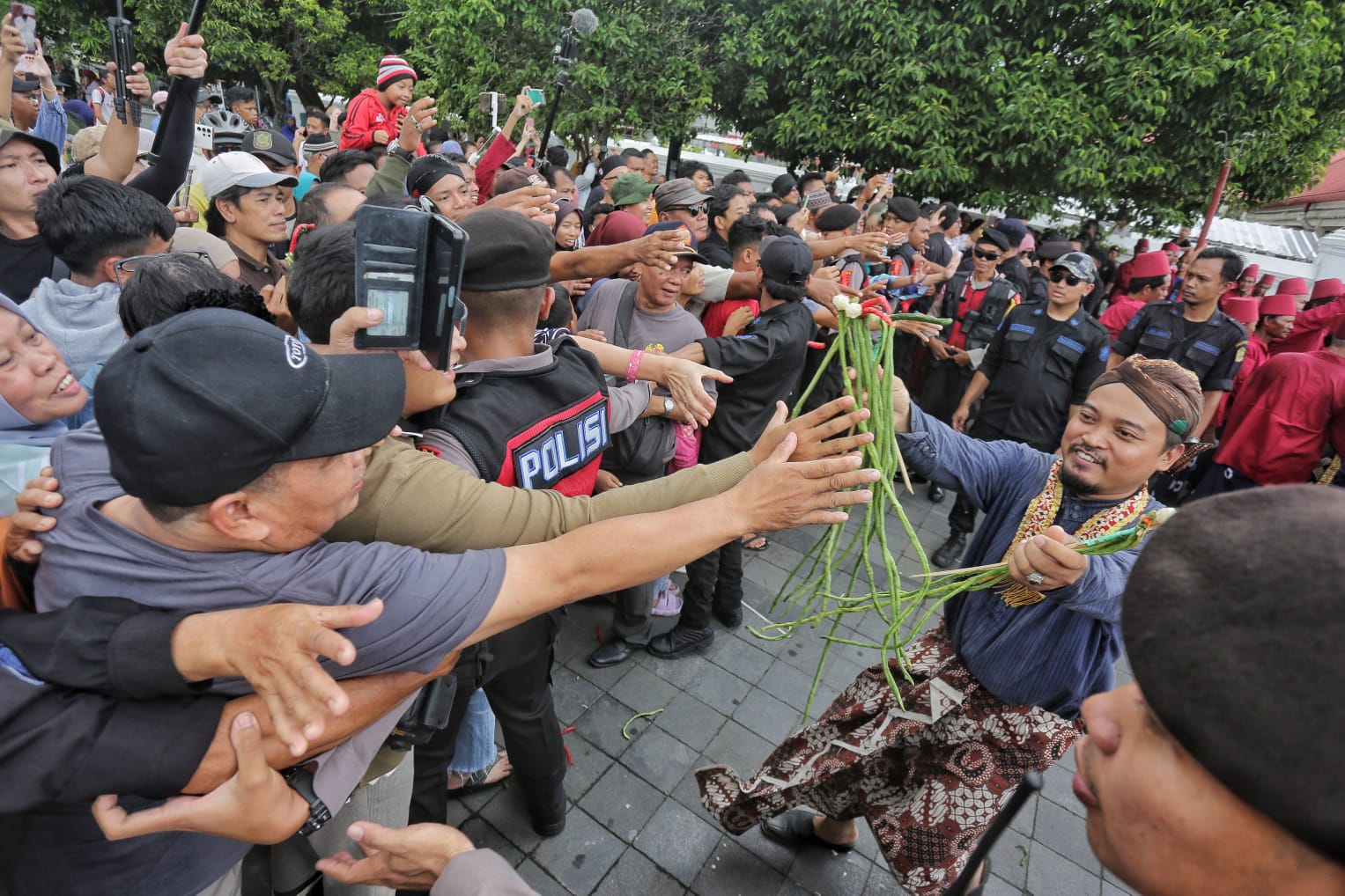 Abdi dalem Keraton Yogyakarta membagikan hasil bumi dari gunungan ke masyarakat