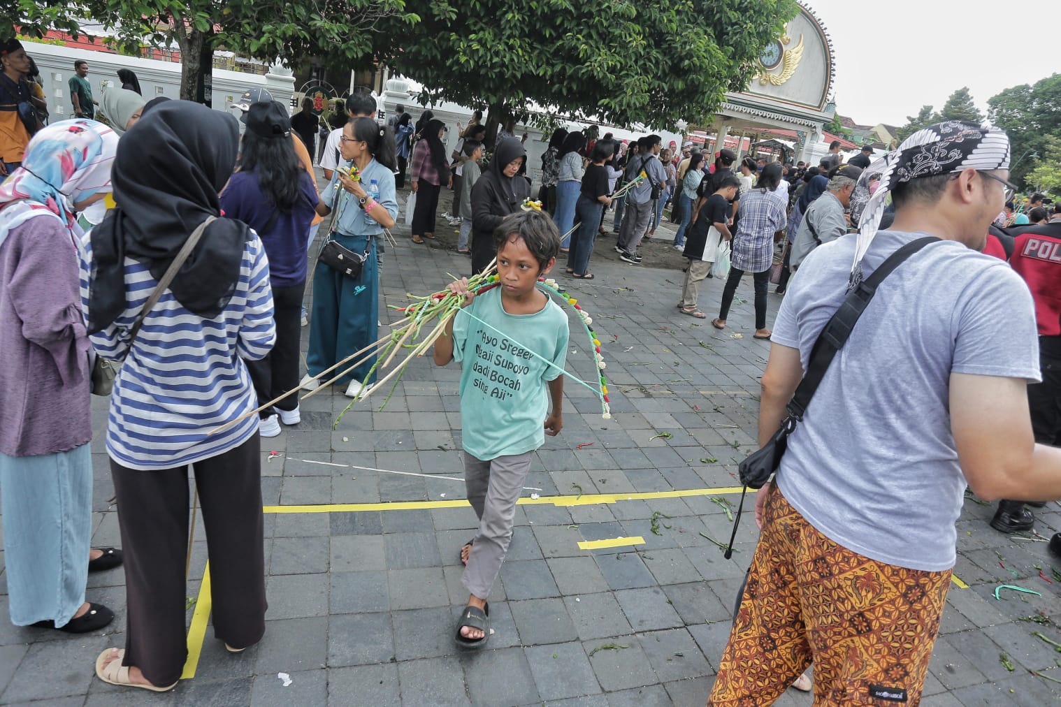 Seorang anak membawa hasil gunungan yang diberikan oleh abdi dalem Keraton Jogja