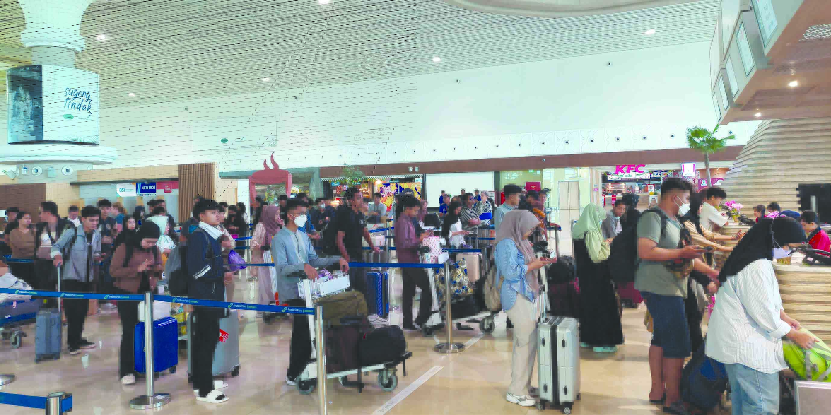 ARUS BALIK: Penumpang saat mengantre di konter untuk memeriksa bagasi di Yogyakarta International Airport (YIA). (ANOM BAGASKORO/RADAR JOGJA)