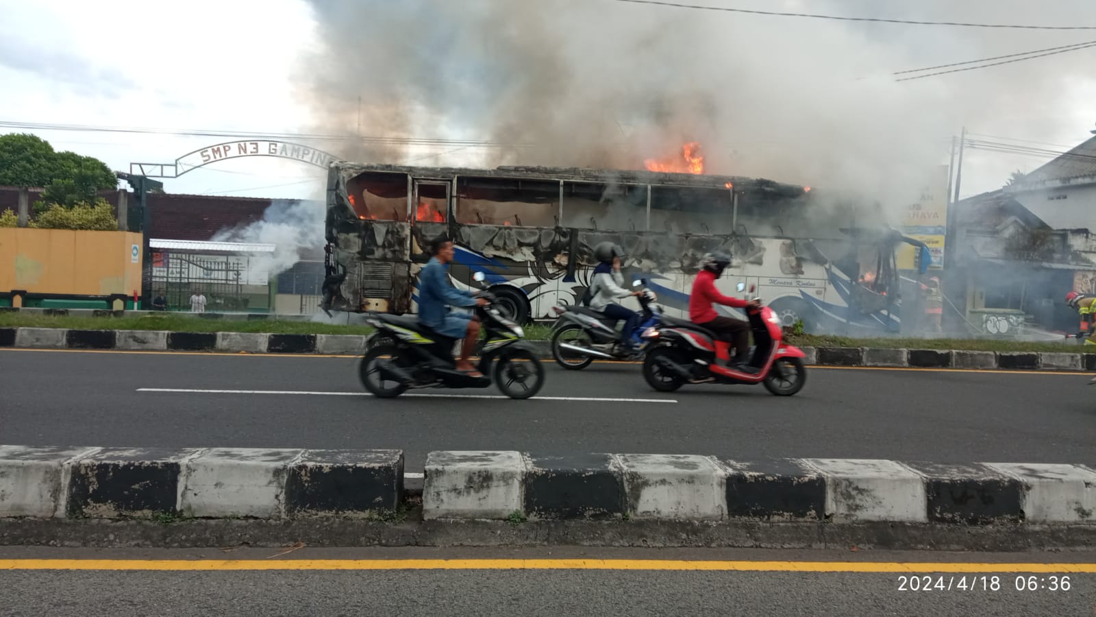 TERBAKAR: Suasana saat petugas pemadam kebakaran melakukan evakuasi bus yang terbakar di Gamping, Sleman pada Kamis (18/4). (Dok BPBD Sleman)