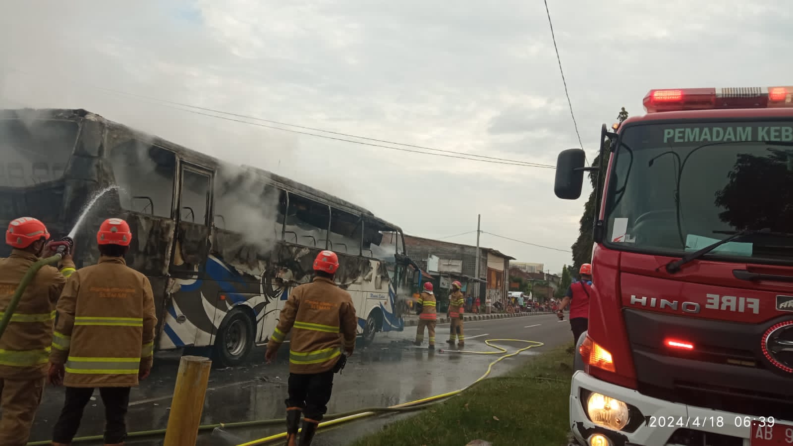TERBAKAR: Suasana saat petugas pemadam kebakaran melakukan evakuasi bus yang terbakar di Gamping, Sleman pada Kamis (18/4). (Dok BPBD Sleman)