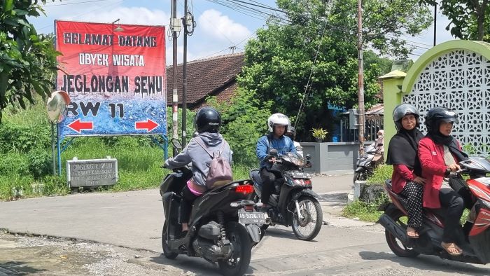 Para pengguna jalan saat melintas di kawasan RW 11 Minomartani yang jalannya berlubang