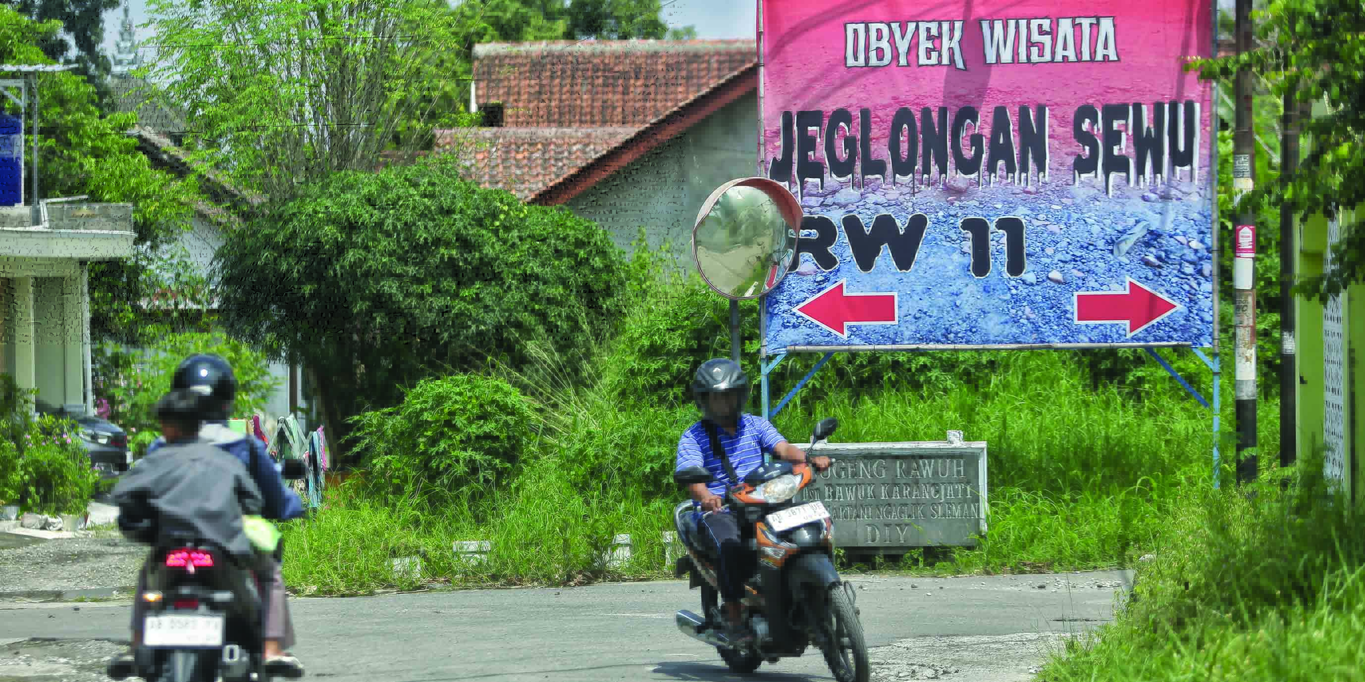 SINDIRAN KERAS: Warga melintas di depan baliho yang berisi sindiran kondisi jalan yang tidak segera diperbaiki.&nbsp;(ELANG KHARISMA DEWANGGA/RADAR JOGJA)