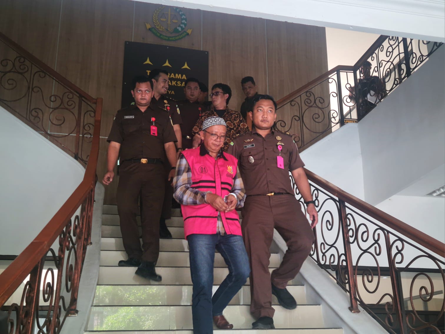 MENUNDUK: Dengan mengenakan rompi merah muda, Kades Krinjing Ismail resmi ditetapkan menjadi tersangka kasus korupsi dan ditahan di Lapas Kelas II A Magelang.