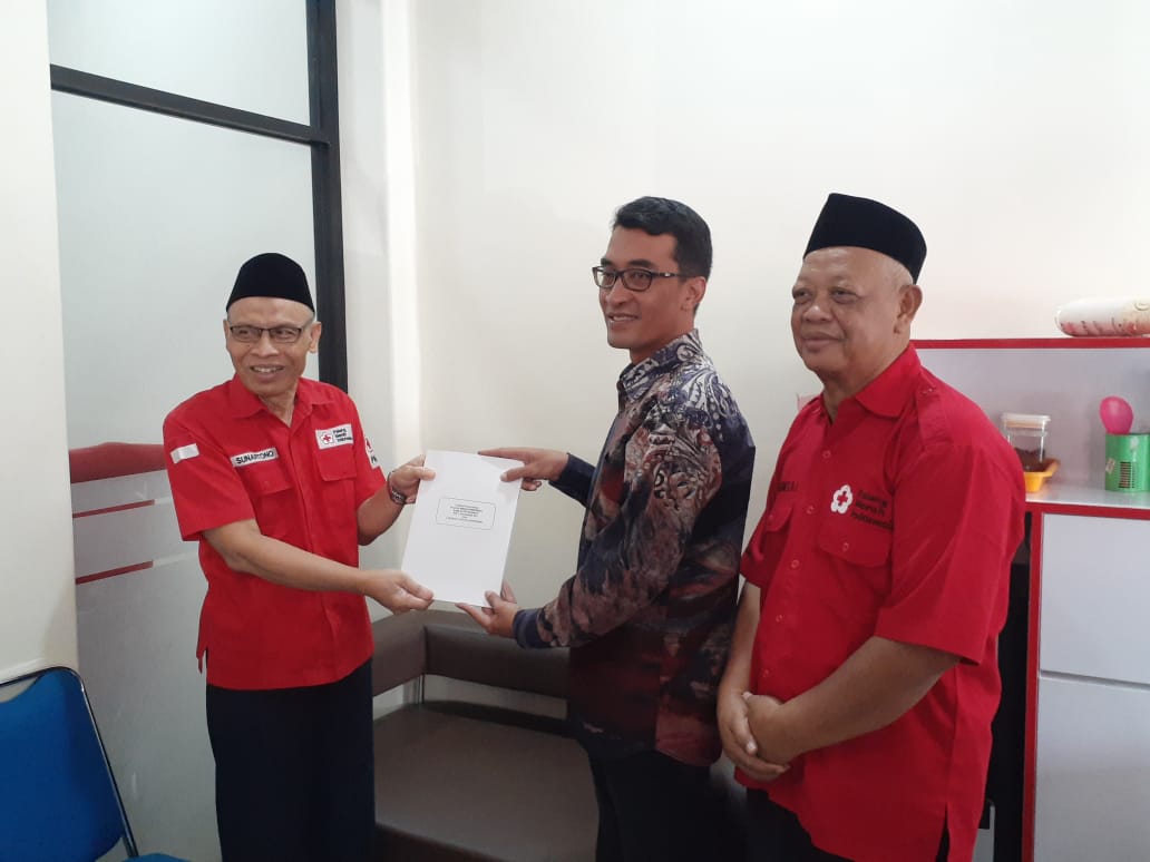 PRESTASI: Ketua PMI Sleman Sunartono saat menerima hasil audit dengan predikat Wajar Tanpa Pengecualian dari akuntan publik R. Gati Reditya Saputra, Senin (22/4).