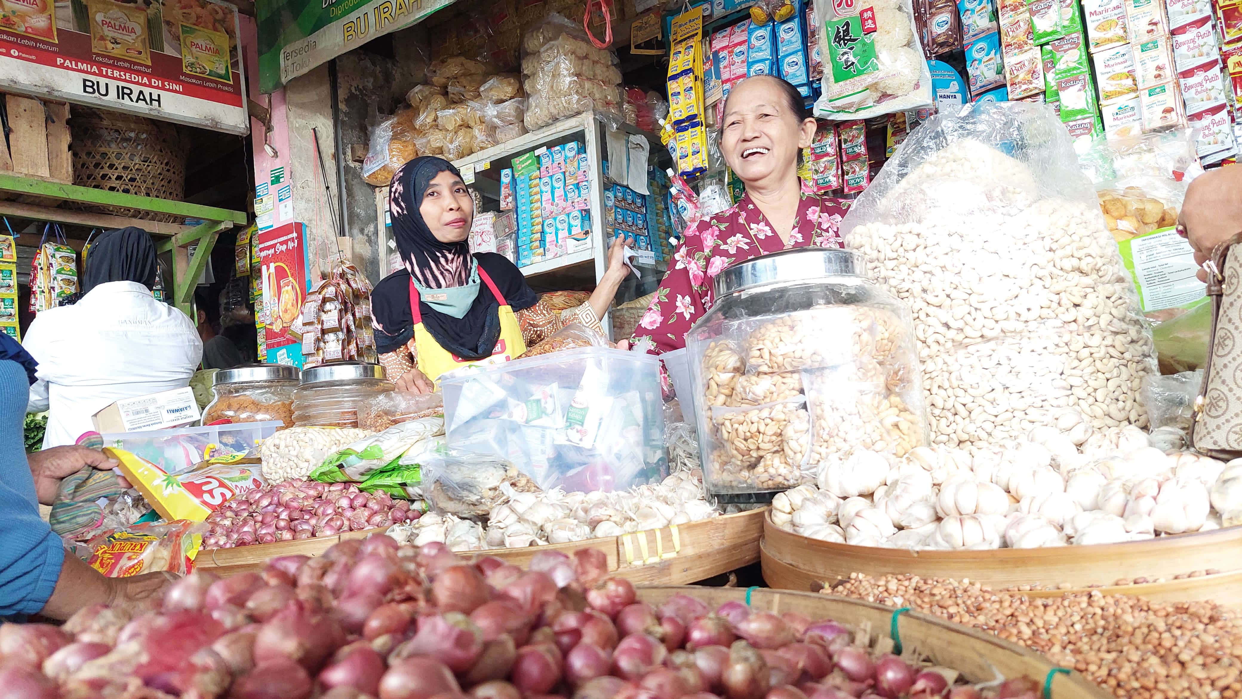 TINGGI: Penjual bawang merah di Pasar Wates menawarkan dagangannya.