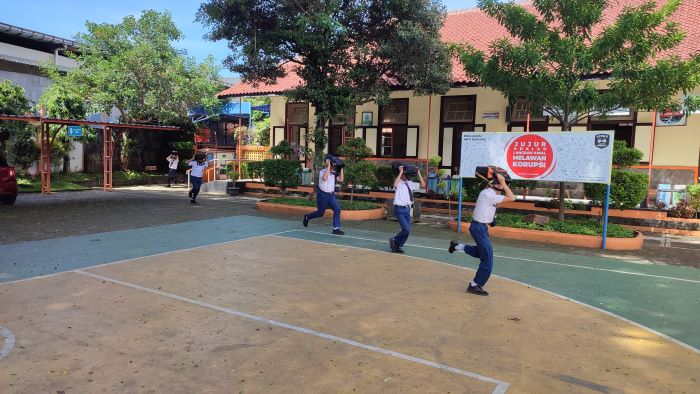 Para siswa SMP N 2 Purworejo berlari sembari melindungi kepala saat mengikuti simulasi gempa bumi oleh BPBD Purworejo dan BMKG Banjarnegara, Senin (29/4).