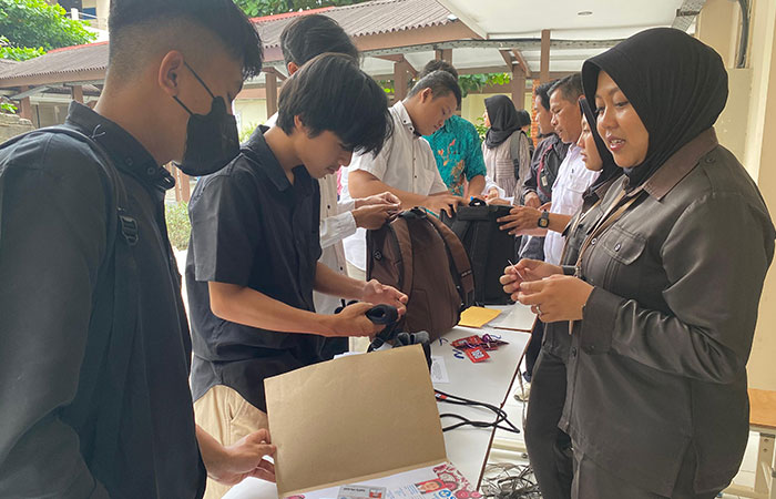 PASTIKAN AMAN: Pengawas saat melakukan pengecekan barang bawaan peserta UTBK SNBT di UPN Veteran Yogyakarta (UPNVY) kemarin (30/4).