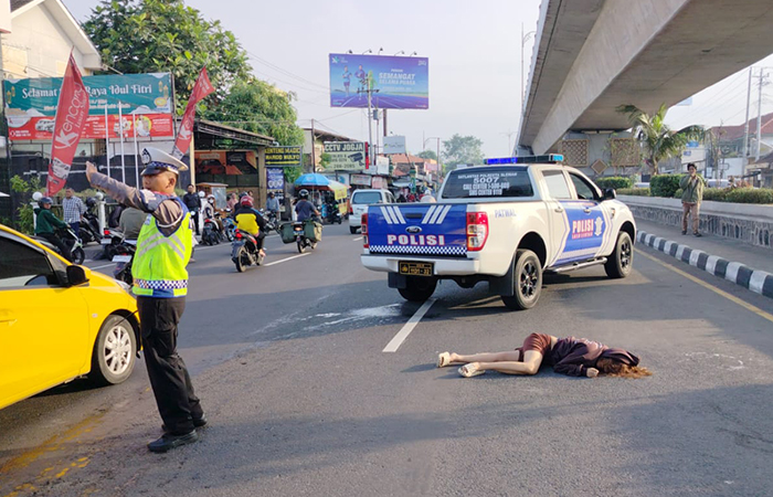 LUKA PARAH: Petugas kepolisian saat melakukan penanganan terhadap PWP, 19, usai meloncat dari Flyover Jombor, Sleman, (2/5).