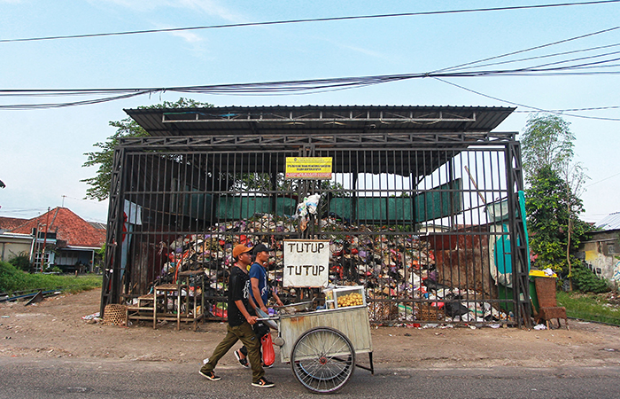 PEMANDANGAN RUTIN: Pengguna jalan melintas di depan tempat pembuangan sampah sementara yang ditutup di kawasan Demangan, Kemantren Gondokusuman, Kota Jogja,(2/5).