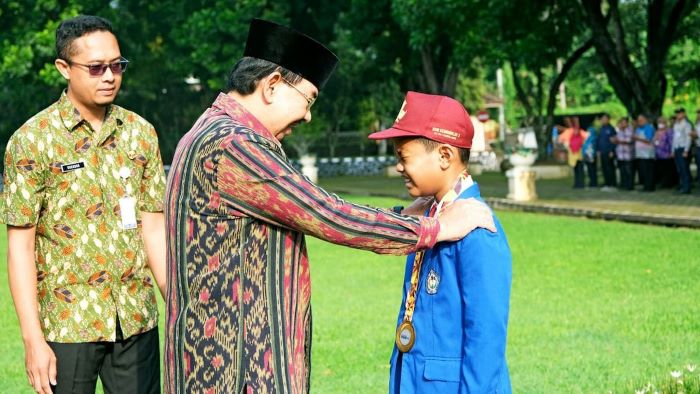 BERPRESTASI: Wakil Wali Kota Magelang M Mansyur saat mengalungkan medali emas kepada Raess Balapati Pradana, Kamis (2/5/2024).