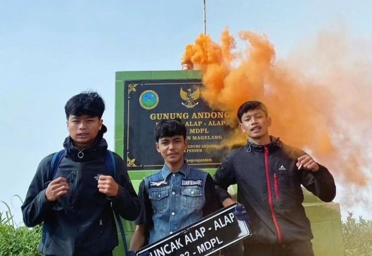 Demi berfoto ria tiga orang pemuda menyalakan flare di Gunung Andong