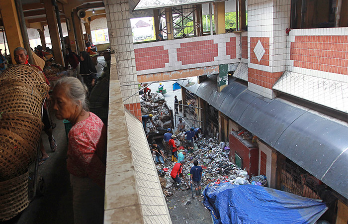 Pekerja mengangkut sampah yang sudah menumpuk berhari-hari di salah satu sudut Pasar Beringharjo sisi timur, Kota Jogja, Senin (6/5).