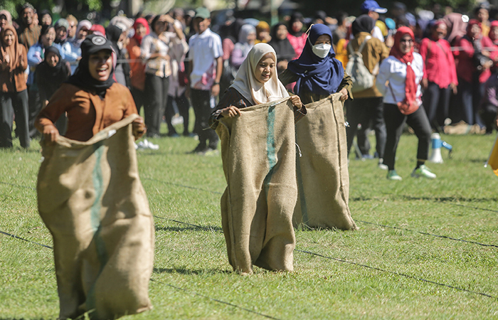 MERIAHKAN HARI JADI: Peserta mengikuti balap karung dan tarik tambang saat lomba permainan tradisional di Lapangan Pemda Sleman, kemarin (7/5).