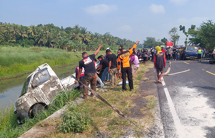 MUATAN BERHAMBURAN: Proses evakuasi pikap pengangkut beras yang tercebur ke sungai melibatkan relawan gabungan serta warga sekitar.Anom Bagaskoro/Radar Jogja