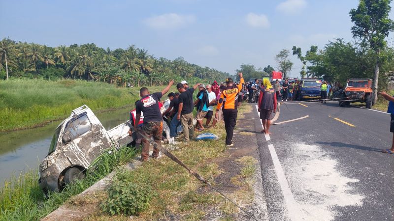 Muatan Berhamburan: Proses evakuasi bangkai pickup melibatkan relawan gabungan beserta warga sekitar.