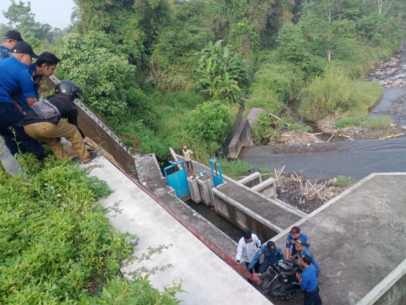 EVAKUASI: Petugas Damkar Kabupaten Magelang serta warga setempat saat berusaha menaikkan sepeda motor yang terperosok ke dasar Sungai Pabelan.&nbsp;