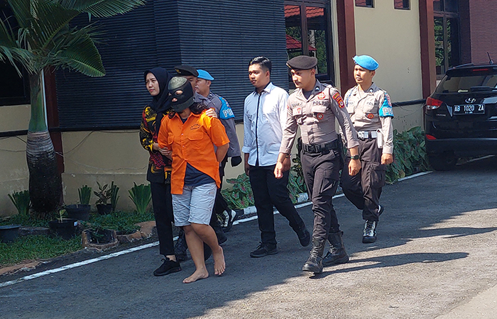 DALIHNYA TOUR LEADER: Tersangka TPPO Muji Lestari, 41, saat digelandang polisi ke tempat acara konferensi kasus ini di Mapolres Kulon Progo, (14/5).