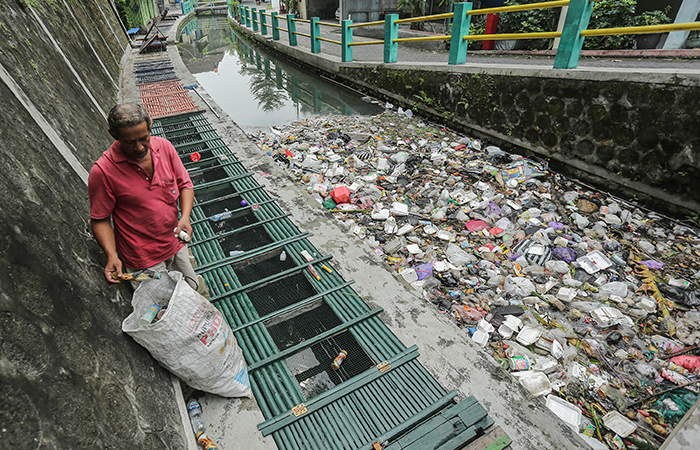 POTENSI BANJIR: Warga mencari botol plastik di tumpukan sampah yang berada di aliran sungai kawasan RTHP Winongo, Patangpuluhan, Jogja, (15/5). Pascapenutupan TPA Piyungan sampah kembali menumpuk.